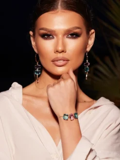 Cauti o Pereche de Cercei Deosebiti cu Cristale? Descopera Colectia Mangata Jewelry Cercei Aurii Statement cu Cristale Lila Albastru MANGATA