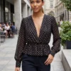 Descoperă bluza de damă neagră cu buline și decolteu elegant. Un model versatil pentru ținute chic, office, casual sau elegante. Comandă online la Mangata.