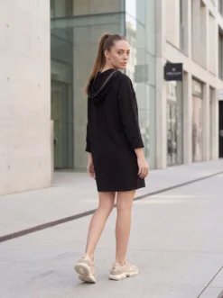 Descoperă rochia midi neagră casual cu glugă de la Mangata. Design modern, material confortabil și croi versatil, ideală pentru ținute urbane de zi.