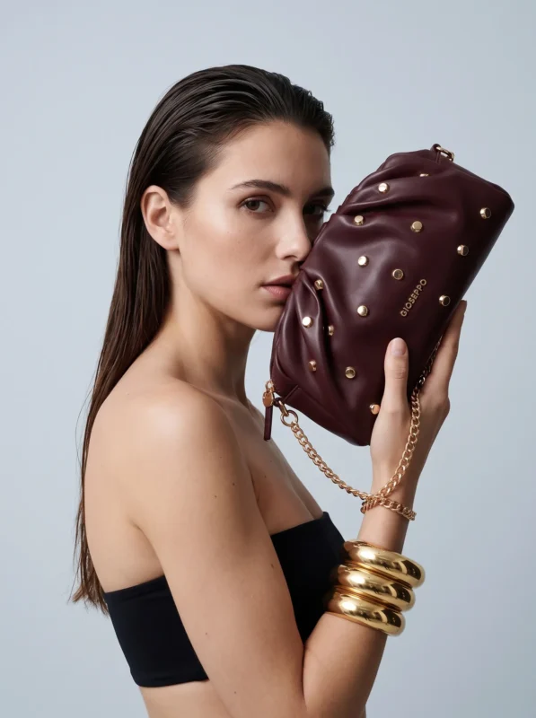 Descoperă geanta crossbody burgundy cu efect texturat și accesorii aurii de la brandul spaniol Gioseppo. Alege un design elegant cu lanț. Cumpără acum!